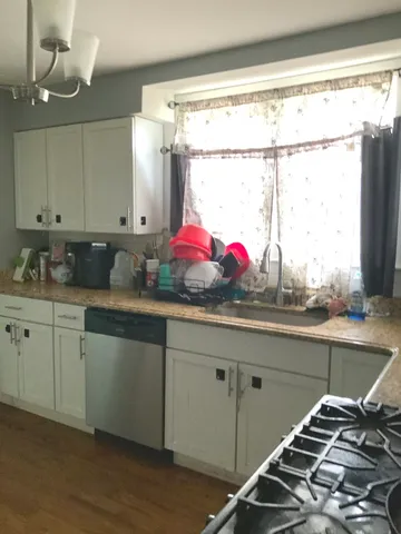 a kitchen with stainless steel appliances cabinets and a large window