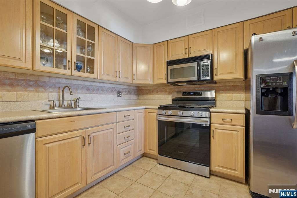 5 Horizon Road, Unit 2304 Fort Lee, NJ 07024 - Photo 16 of 33 a kitchen with cabinets stainless steel appliances and a sink