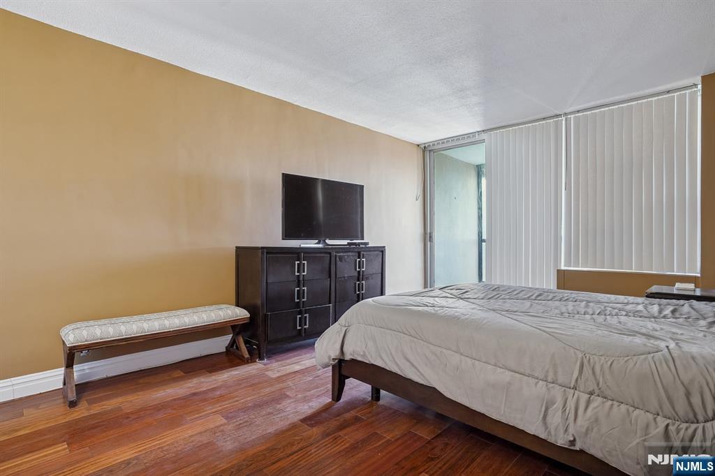 5 Horizon Road, Unit 2304 Fort Lee, NJ 07024 - Photo 23 of 33 a bedroom with a bed and a chair