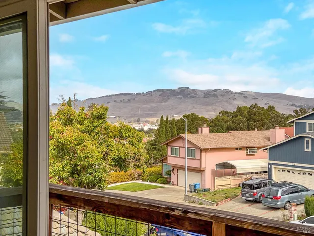 an aerial view of residential houses with outdoor space and trees