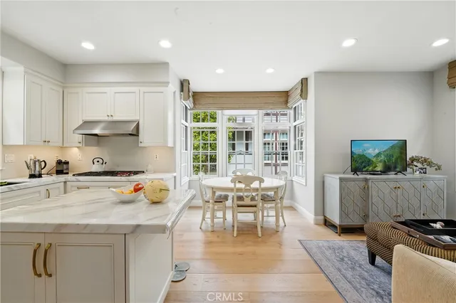 a kitchen with stainless steel appliances granite countertop a refrigerator a sink a stove and white cabinets