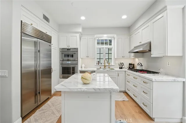 a kitchen with stainless steel appliances granite countertop a sink stove and cabinets