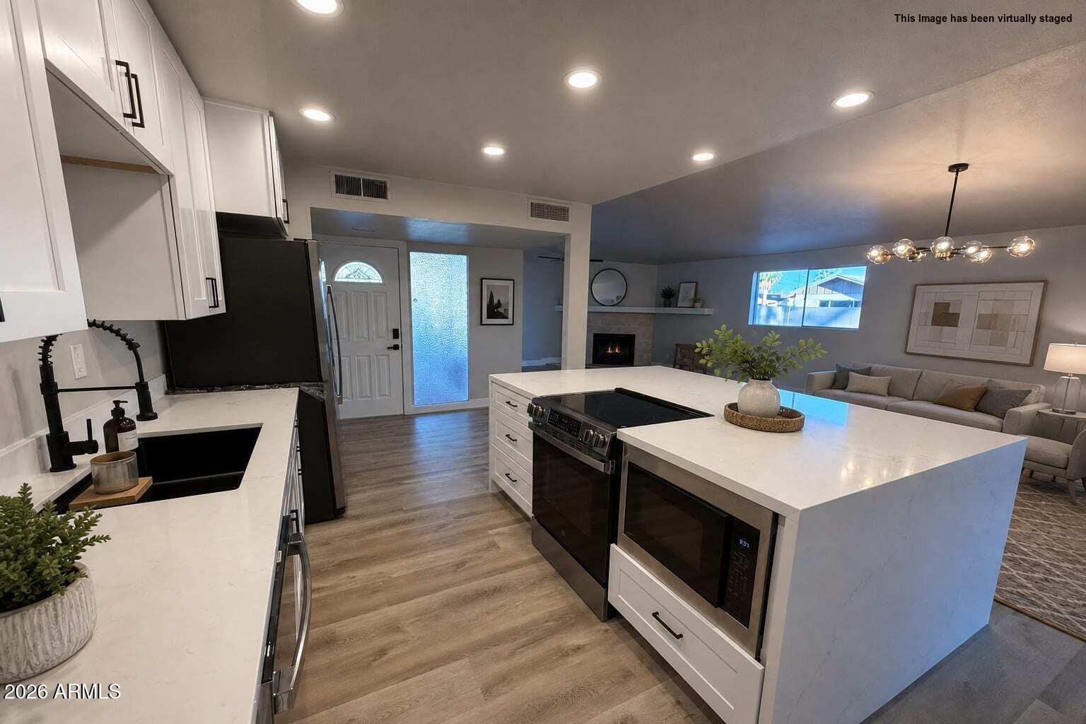 5420 North Granite Reef Road Scottsdale, AZ 85250 - Photo 3 of 30 a large kitchen with stainless steel appliances a large counter top a stove a chimney a sink and a refrigerator