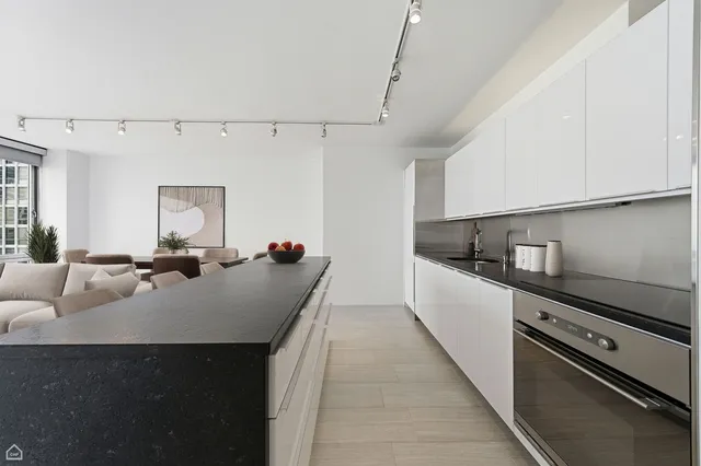a large kitchen with a stove and white cabinets