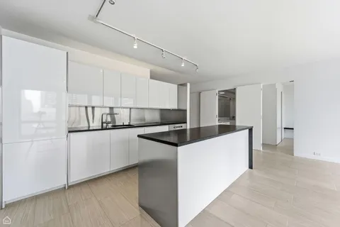 a kitchen with granite countertop white cabinets and white appliances