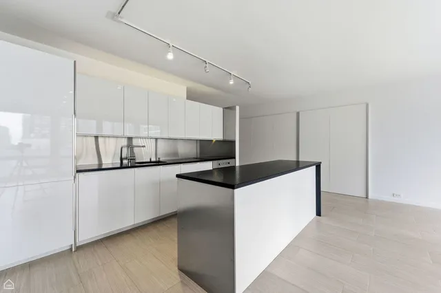 a kitchen with stainless steel appliances white cabinets and wooden floor