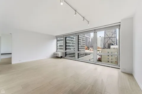 a view of an empty room with windows and city view