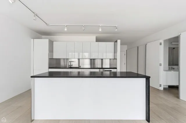 a kitchen with stainless steel appliances granite countertop a sink a stove and a refrigerator with wooden floor