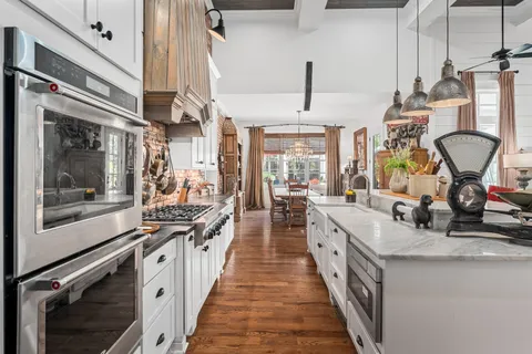 a dining room with furniture a chandelier and wooden floor