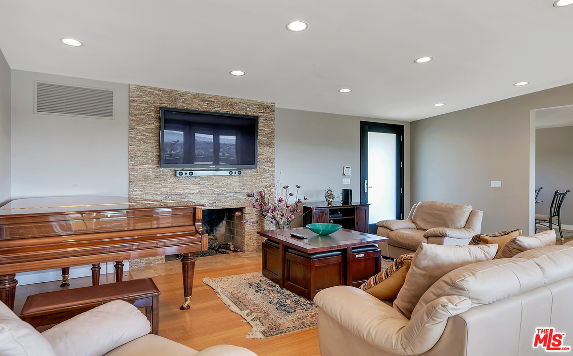 3921 Cody Road Sherman Oaks, CA 91403 - Photo 5 of 36 a living room with furniture a fireplace and a flat screen tv