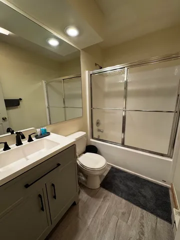 a bathroom with a sink toilet vanity and shower