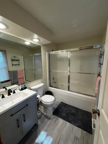 a bathroom with a sink toilet a mirror and shower