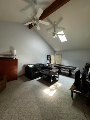 a living room with furniture gym equipment and a ceiling fan