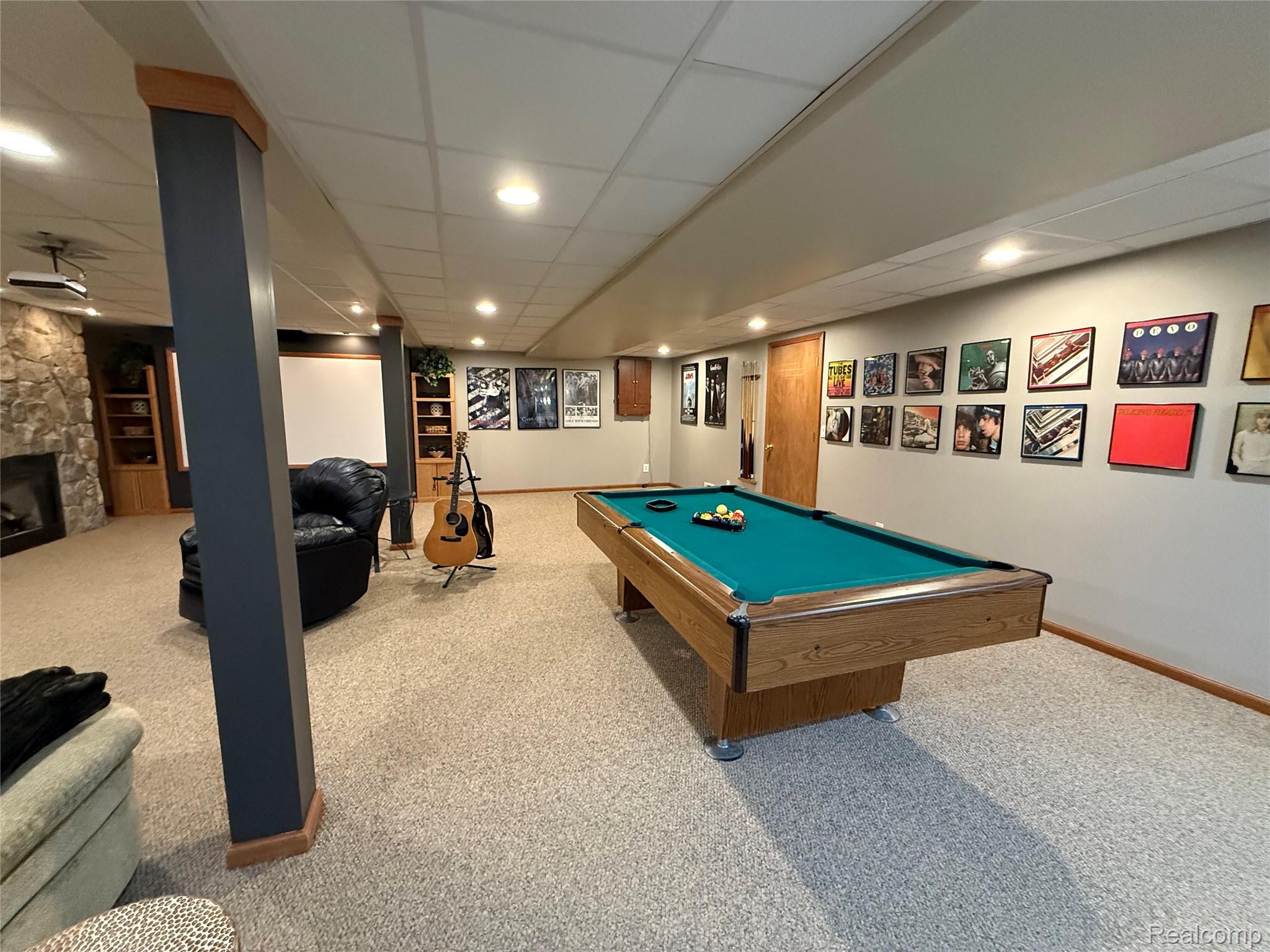 3668 East Allen Road Howell, MI 48855 - Photo 14 of 18 Spacious recreation room featuring a pool table, stone-surround fireplace, built-in shelving, and recessed lighting