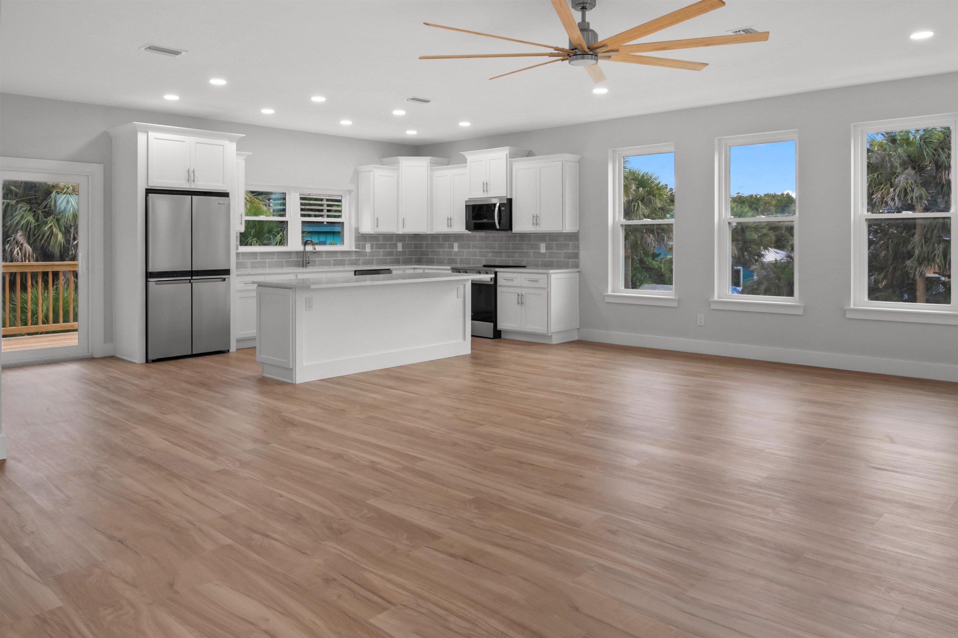 137 Ferrol Road St. Augustine, FL 32084 - Photo 20 of 53 an open kitchen with white cabinets wooden floor and stainless steel appliances