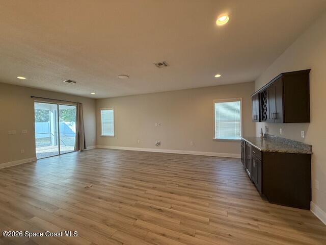 4570 Hebron Drive Merritt Island, FL 32953 - Photo 10 of 23 a view of a kitchen and an empty room with wooden floor and a window