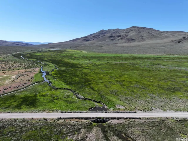 a view of a mountain with a field