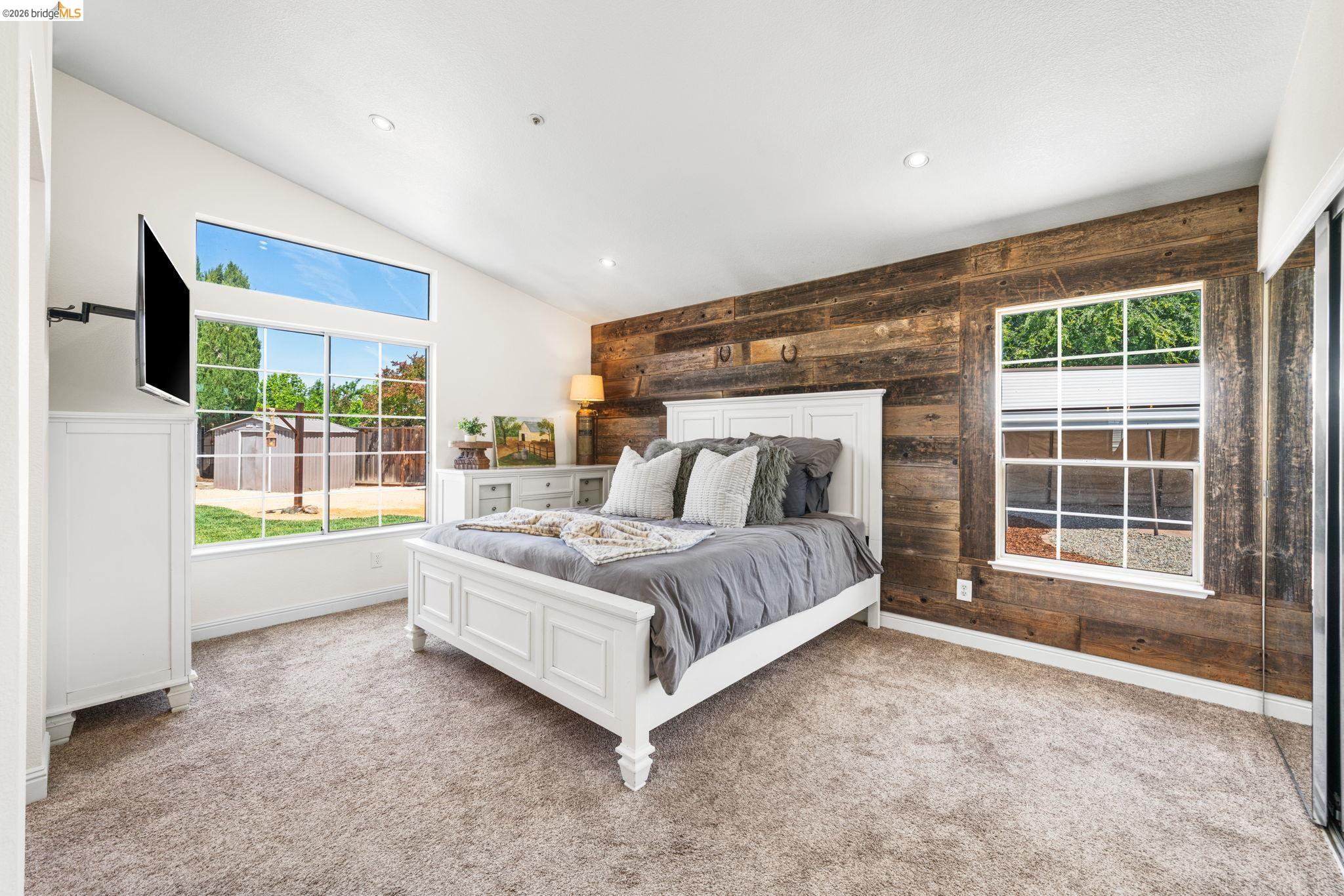 1186 El Rio Court Livermore, CA 94551 - Photo 18 of 60 Vaulted ceiling room featuring a wood-panel accent wall and recessed lighting