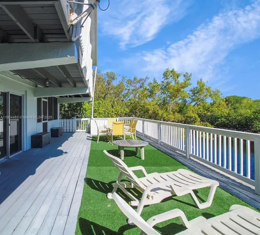 a view of a patio with couches chairs and wooden floor