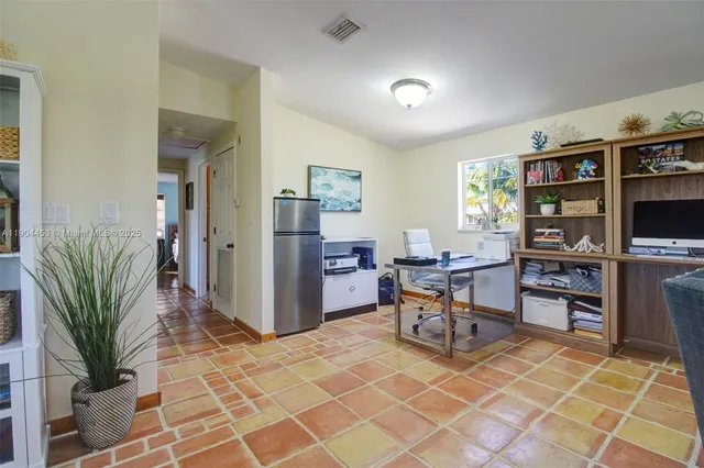 a work room with furniture a bookshelf and a wooden floor