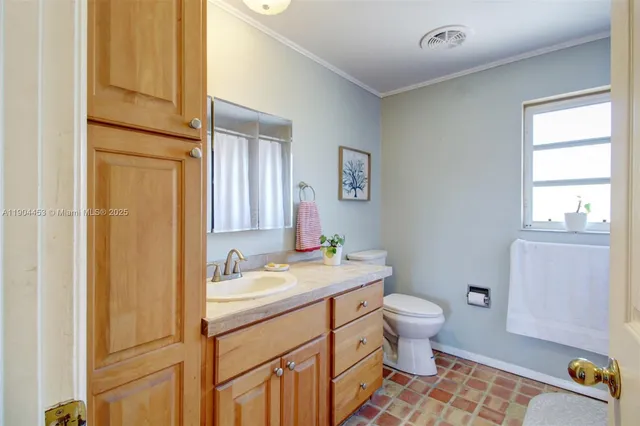 a bathroom with a sink toilet and window