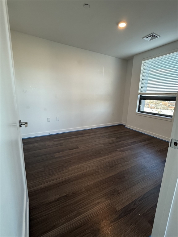466 River Street, Unit 516 Boston, MA 02126 - Photo 3 of 16 an empty room with wooden floor and windows