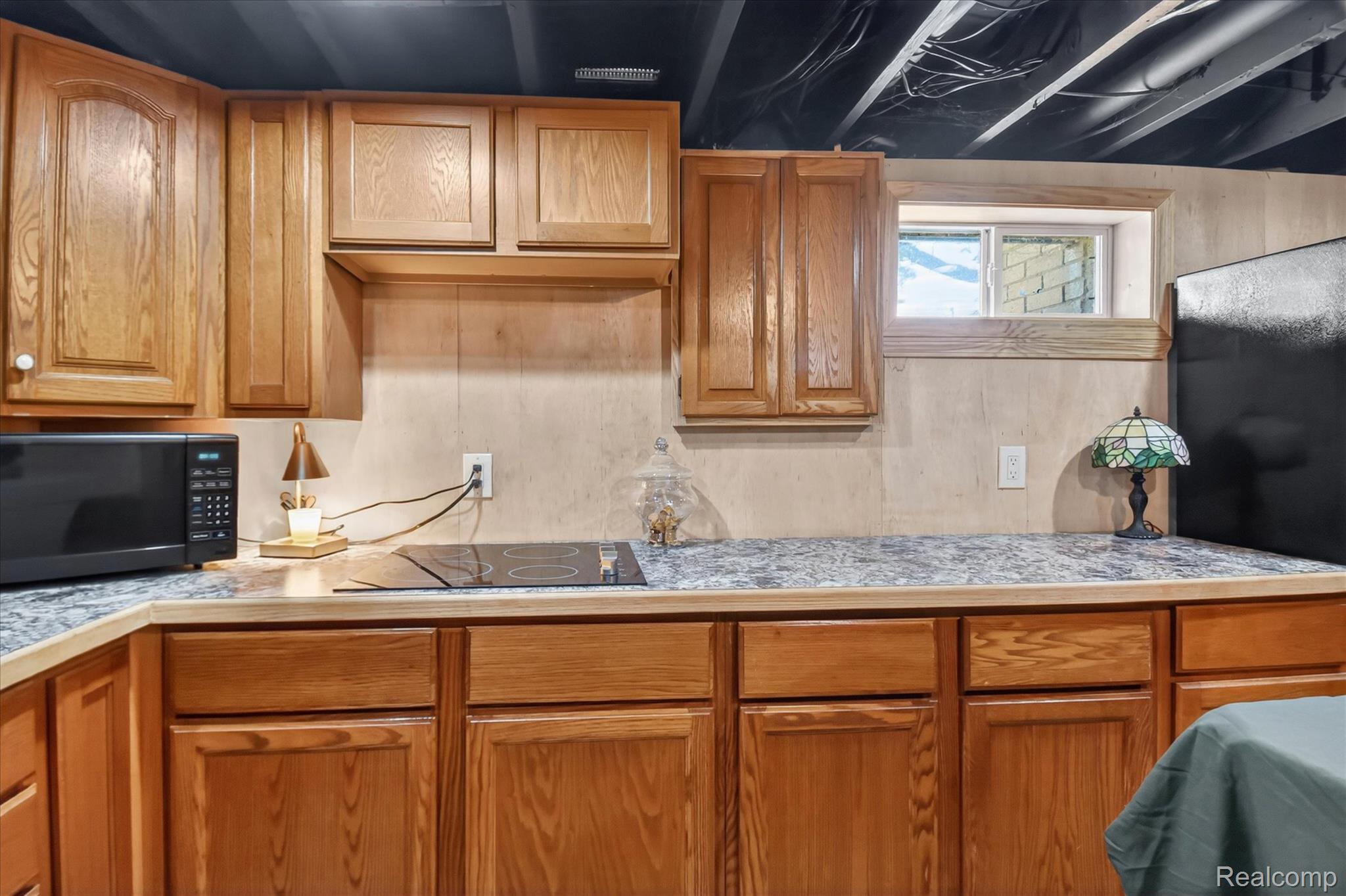 3949 West Burns Line Road Brown City, MI 48416 - Photo 47 of 70 Kitchenette featuring wood cabinetry, laminate countertops, a built-in cooktop, and a window