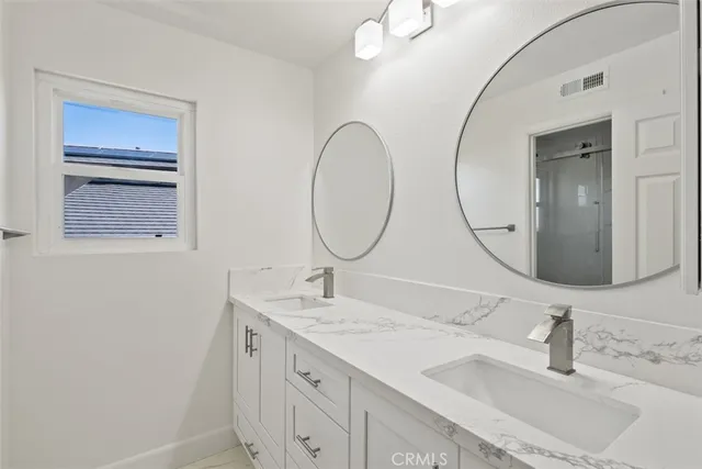a bathroom with a double vanity sink and a mirror