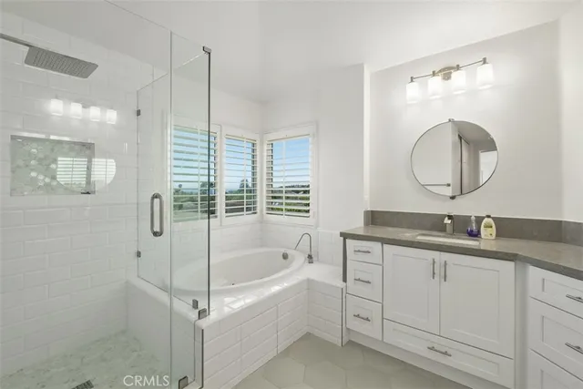 a bathroom with a granite countertop sink a mirror and a bathtub