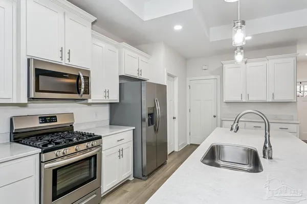 a kitchen with white cabinets and stainless steel appliances