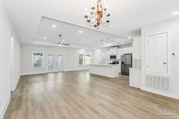 a view of a kitchen with kitchen island stainless steel appliances refrigerator and wooden floor