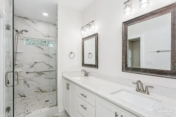a bathroom with a double vanity sink mirror and shower
