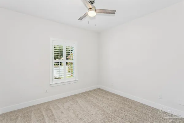 an empty room with a window and a ceiling fan
