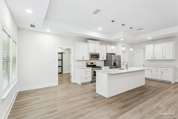 a view of kitchen with stainless steel appliances refrigerator stove microwave and cabinets