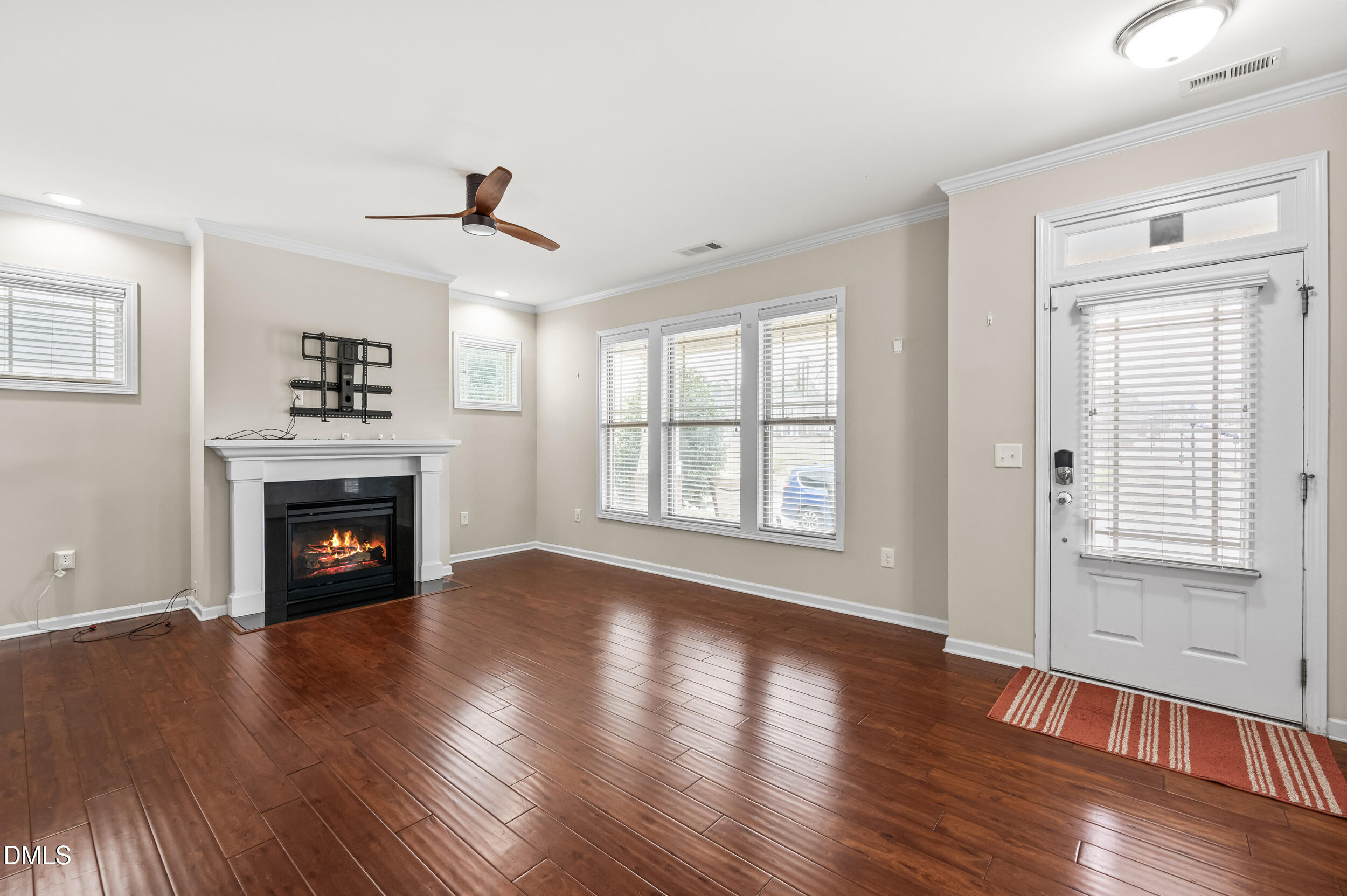 1301 Oatney Ridge Lane Morrisville, NC 27560 - Photo 8 of 38 a view of an empty room with wooden floor fireplace and a window