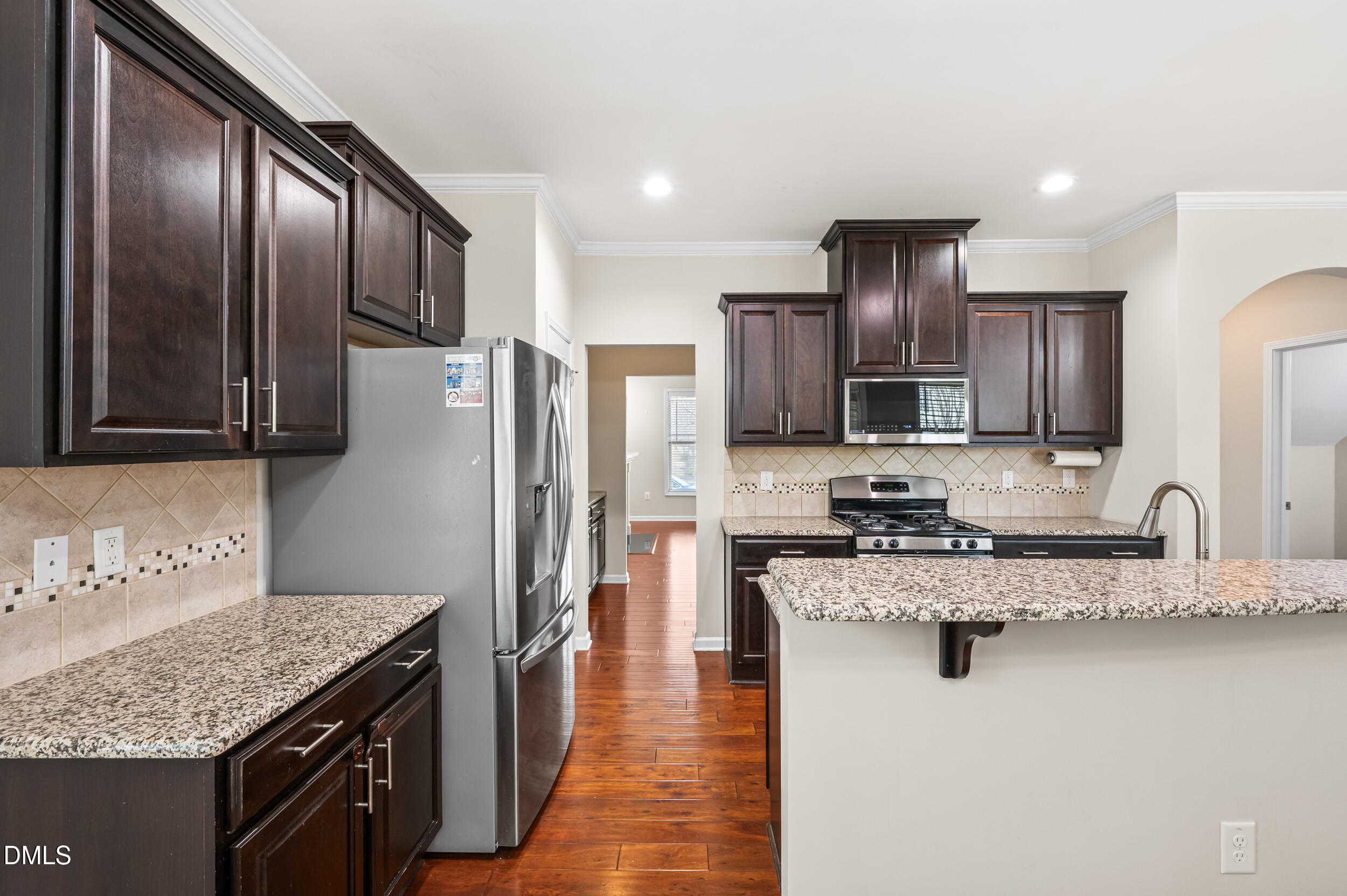 1301 Oatney Ridge Lane Morrisville, NC 27560 - Photo 14 of 38 a kitchen with stainless steel appliances granite countertop a sink stove and refrigerator