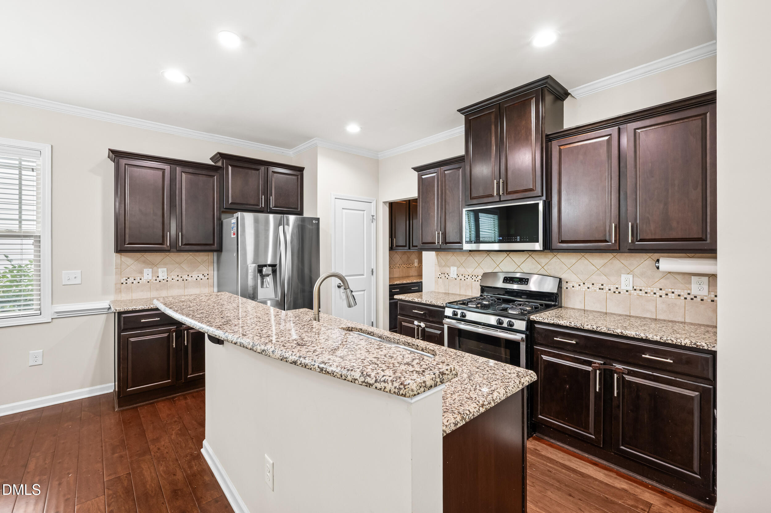 1301 Oatney Ridge Lane Morrisville, NC 27560 - Photo 15 of 38 a kitchen with stainless steel appliances granite countertop a stove refrigerator sink and microwave