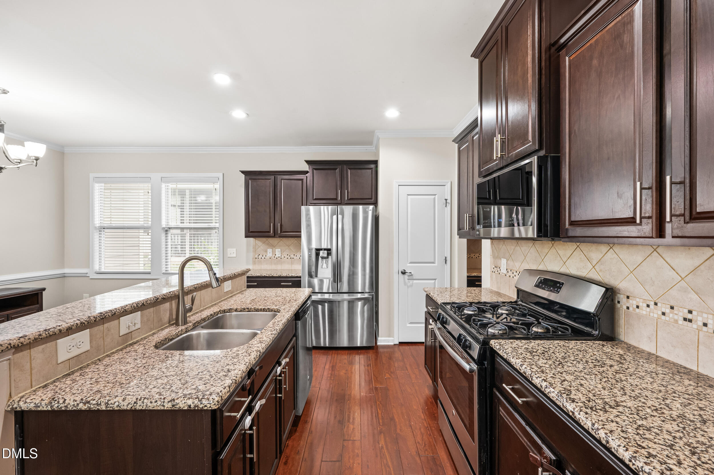 1301 Oatney Ridge Lane Morrisville, NC 27560 - Photo 16 of 38 a kitchen with granite countertop a sink stove and refrigerator