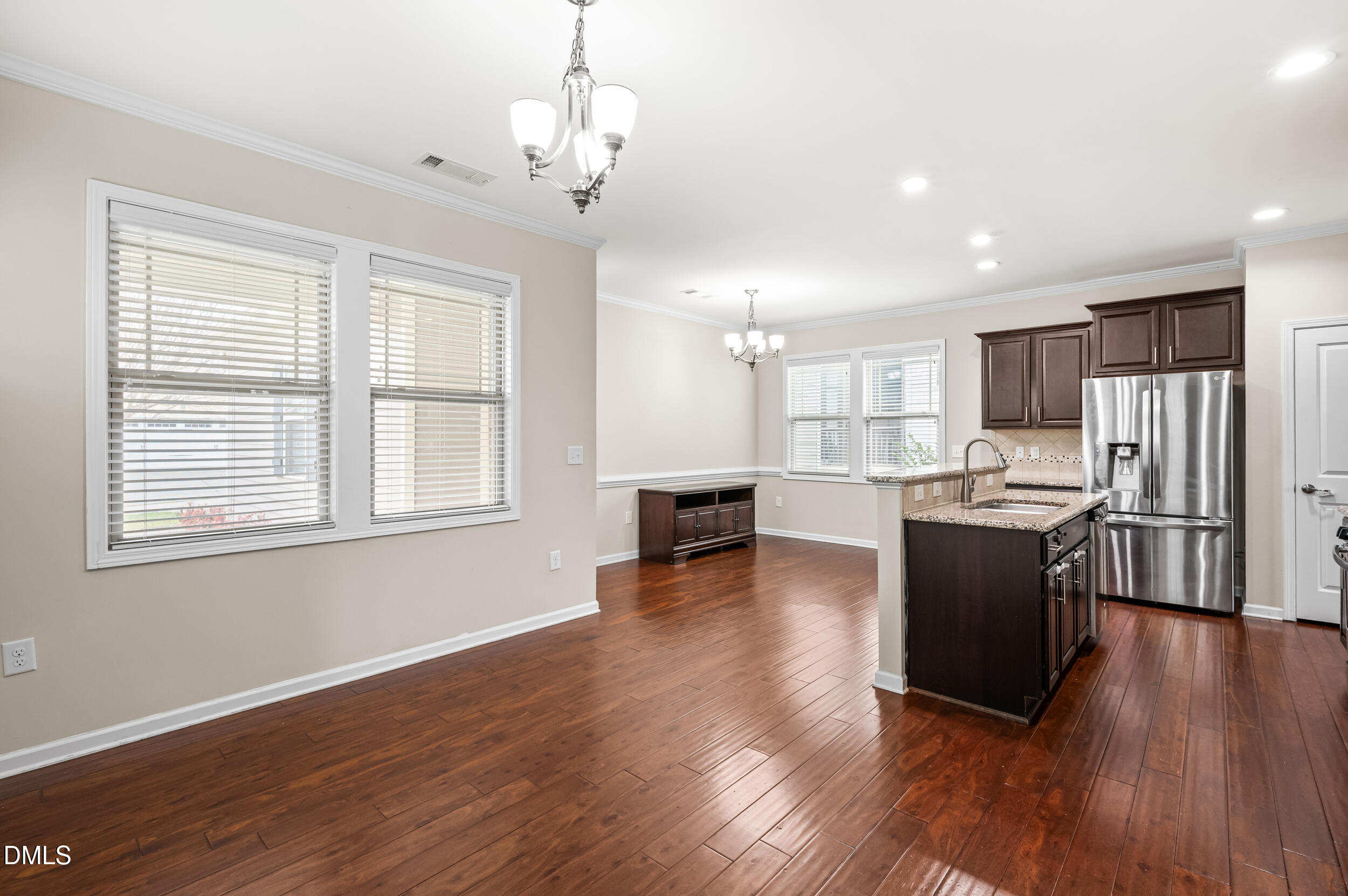 1301 Oatney Ridge Lane Morrisville, NC 27560 - Photo 20 of 38 a large open kitchen with stainless steel appliances granite countertop a refrigerator stove top oven and cabinets with wooden floor