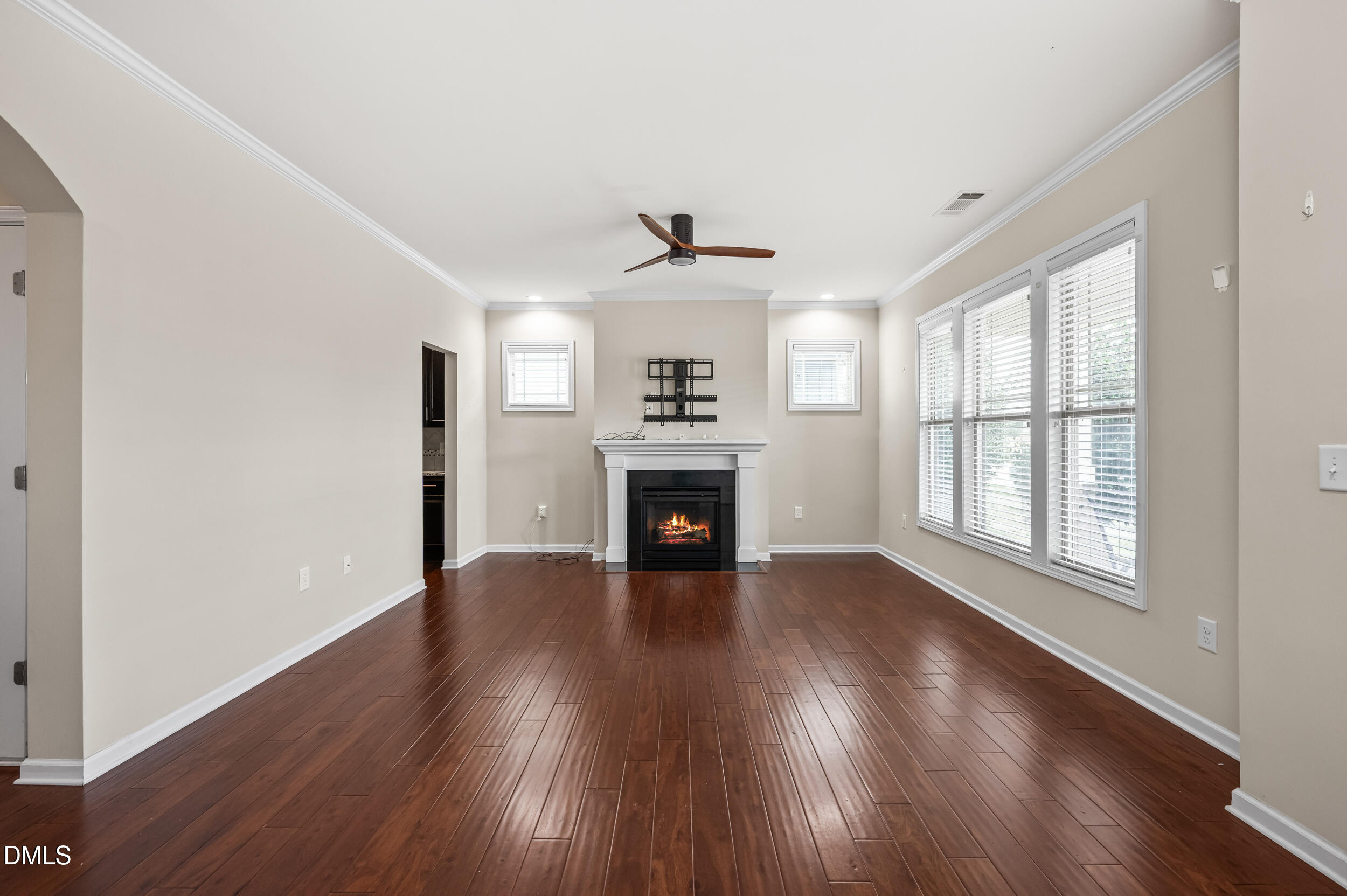 1301 Oatney Ridge Lane Morrisville, NC 27560 - Photo 7 of 38 an empty room with wooden floor fireplace and windows