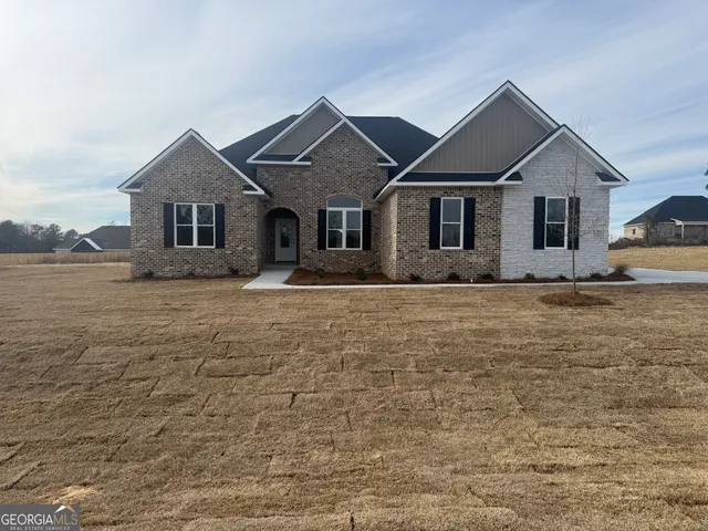 a front view of house with yard and trees around