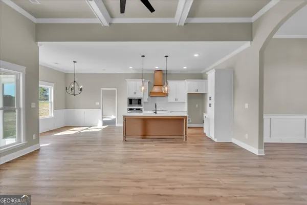an empty room with wooden floor a fireplace a ceiling fan a fireplace and windows