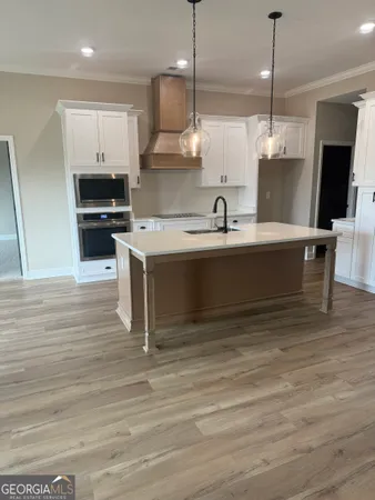 a view of a kitchen with a flat screen tv and a wooden floor