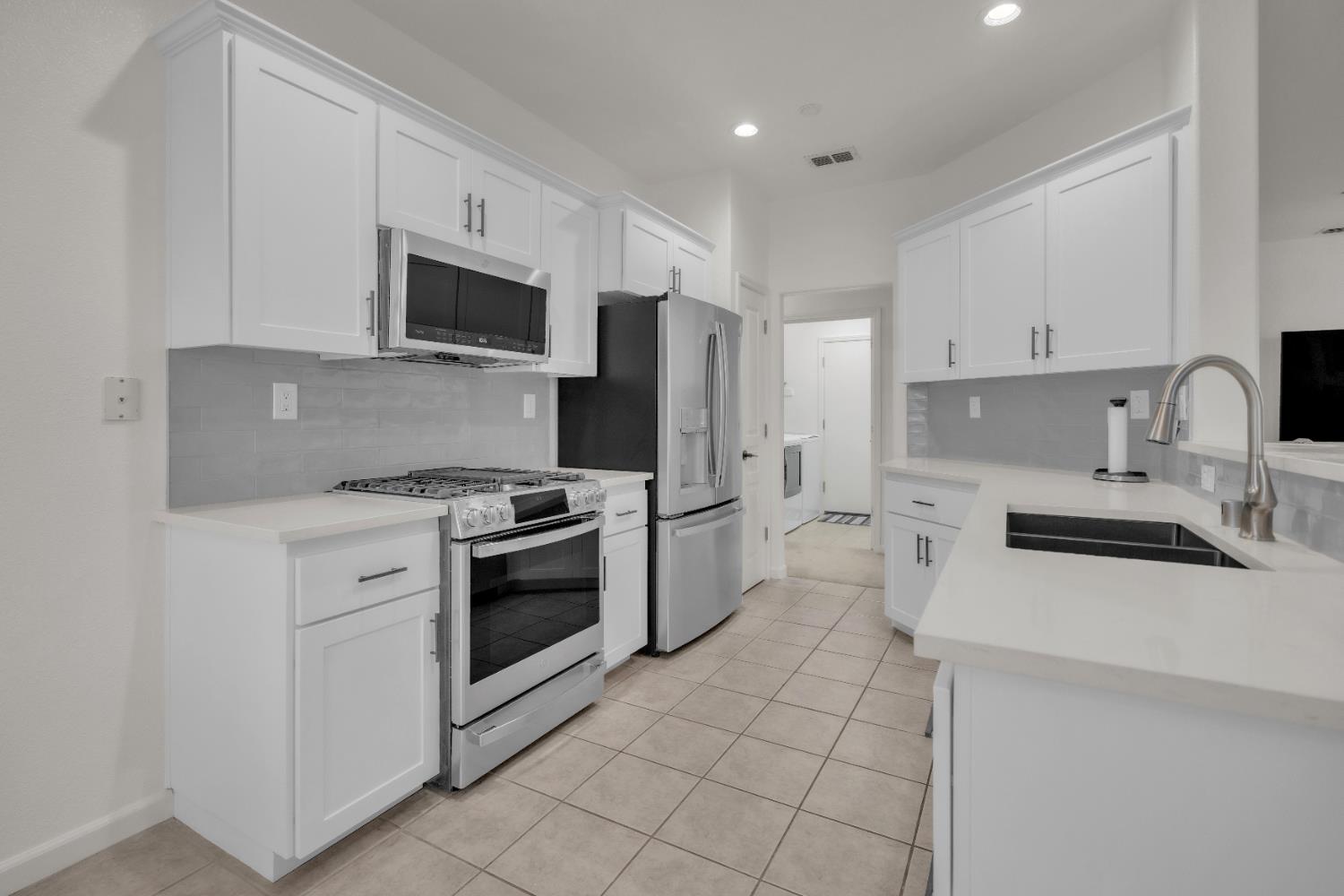 3509 Boulder Ridge Court Rocklin, CA 95765 - Photo 4 of 46 a kitchen with stainless steel appliances a stove a sink a microwave and cabinets