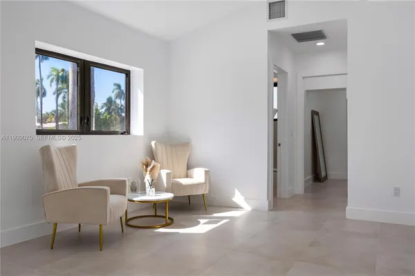 a living room with furniture a window and a painting on the wall