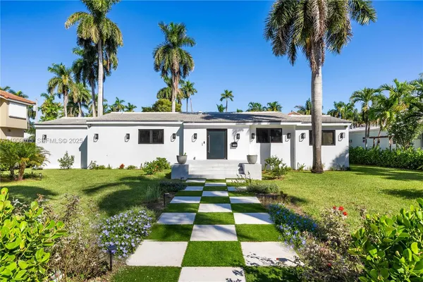front view of house with a yard and potted plants