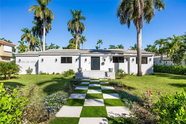 front view of house with a yard and potted plants