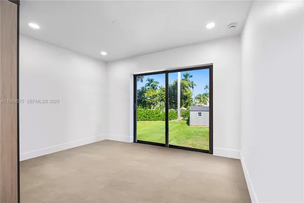 an empty room with wooden floor and balcony