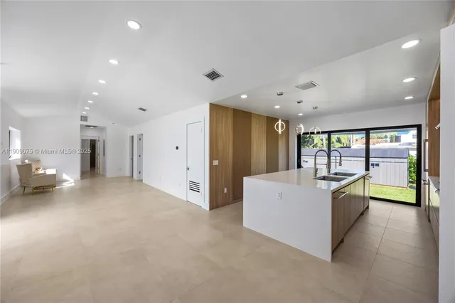 a large white room with stainless steel appliances a large window