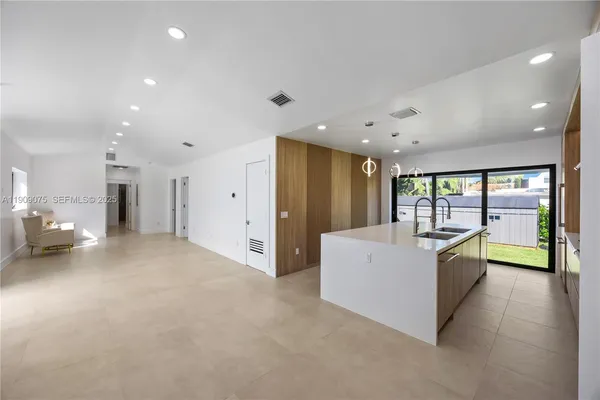 a large white room with stainless steel appliances a large window